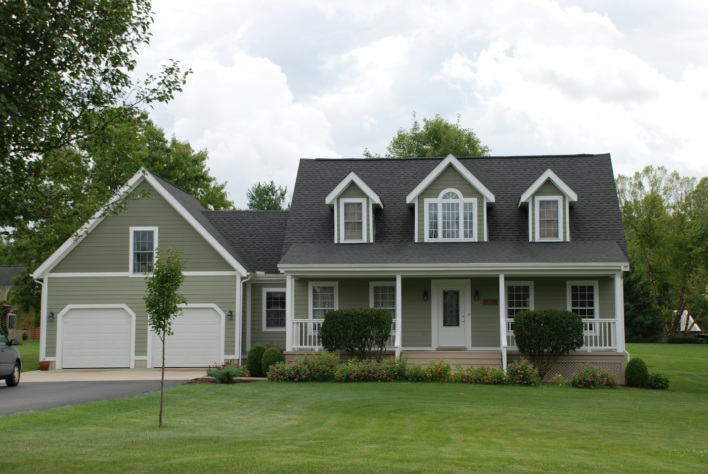 New England cape with dormers, attached garage and new siding