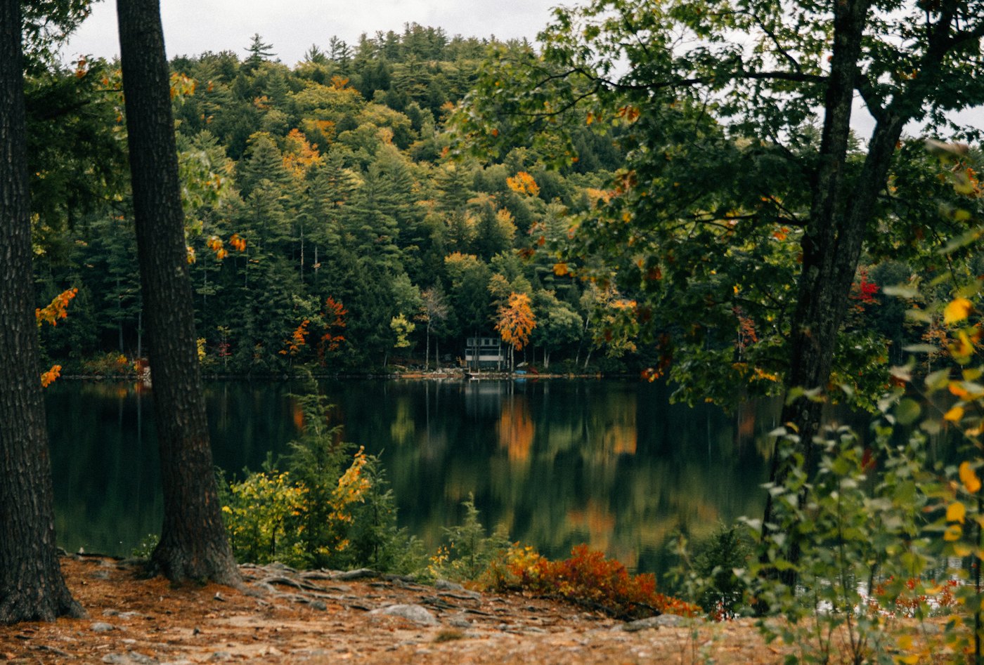 Maine lake in autumn with a camp along the far shore